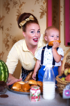 Mother and son in the kitchen with pastries. Studio shot, home interior.の写真素材