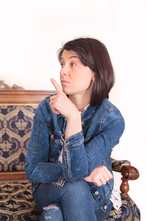 A beautiful young woman makes a quieter gesture, photo in the interior.の写真素材