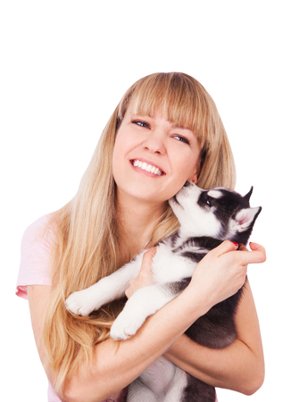Happy women with her puppy Husky in the studio. Isolated on white background.の写真素材