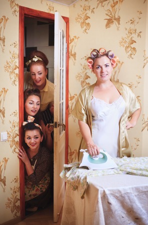 Scene with a housewife and friends. Humorous studio shot in a retro style.の写真素材