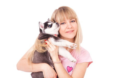 Happy women with her puppy Husky in the studio. Isolated on white background.の写真素材