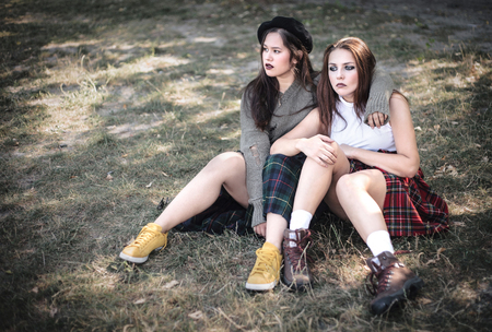 Two girls spend time together outdoors. The concept of difficult teenagers, bad students. Teenage problems.の写真素材