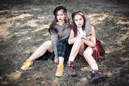 Two girls spend time together outdoors. The concept of difficult teenagers, bad students. Representatives of youth subcultures.の写真素材