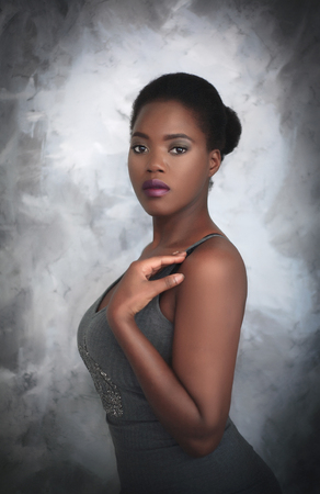 Portrait of a beautiful young african american woman in studio on gray background.の写真素材
