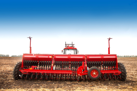 Modern tractor in the field with complex for the treatment and plowing of soil. The concept of work in a fields and agriculture industry.の写真素材