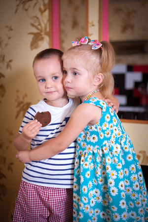 Cute children, boy and girl hugging in the kitchen in home interior.の写真素材