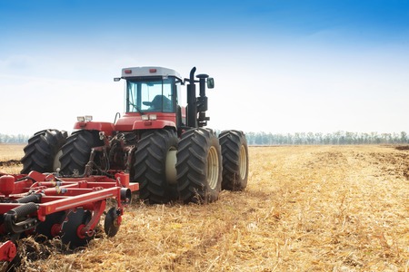 Modern tractor in the field during planting. The concept of agricultural industry. Copy space.の写真素材