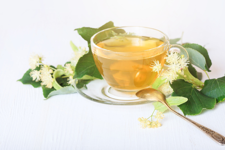 Linden tea on a white table in a glass cup. Flower tea, herbal medicine.の写真素材