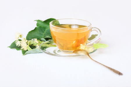 Linden tea on a white table in a glass cup. Flower tea, herbal medicine.の写真素材