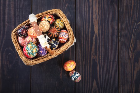 Easter decorated eggs in the basket, on a wooden background. Copy space, easter background.の写真素材