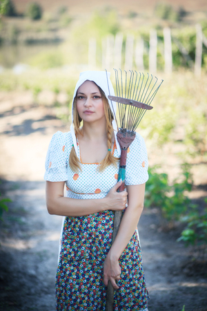 Young women working in her vegetable garden. Vintage rural look.の写真素材