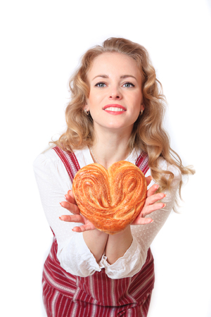 Portrait of cute smiling woman with pastries in her hands in the studio on white backgroundの写真素材