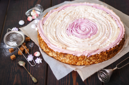 Pink cake with berries and meringue on the kitchen table. Close-up.の写真素材