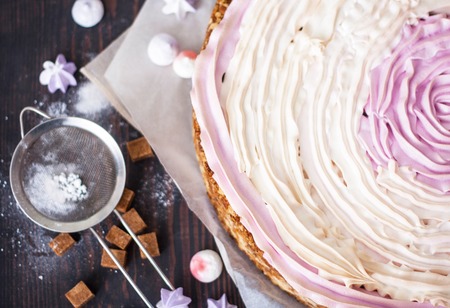 Pink cake with berries and meringue on the kitchen table. Close-up.の写真素材