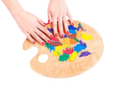 Palette with paints and female hands isolated on white background. Close-up.の写真素材
