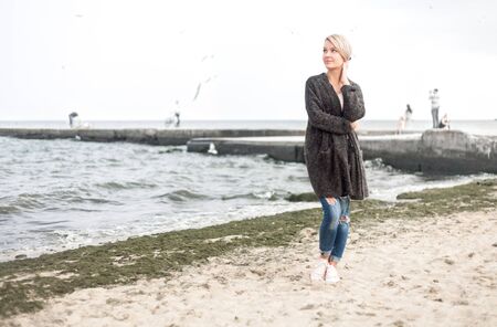 Attractive woman wearing a warm cardigan at the cold beach. Stock image.の写真素材
