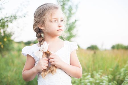 Closeup portrait of a beautiful little girl outdoors in summer.の写真素材