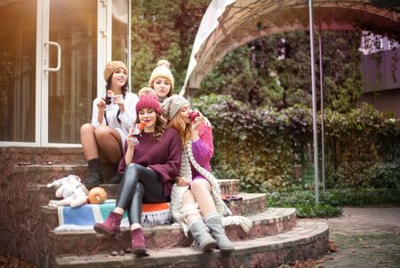 Women are best friends with fruit on a picnic in the countryside. Outdoors lifestyle fashion portrait.の写真素材