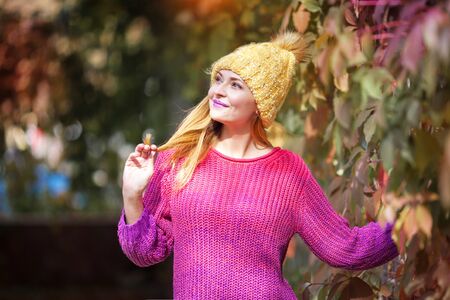 Happy lifestyle portrait of a beautiful young model girl with a sweet smile in a warm autumn hat.の写真素材