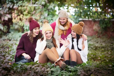 Portrait of best friends in autumn clothes on a walk in the park.の写真素材