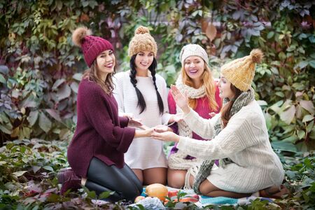 Portrait of best friends in autumn clothes on a walk in the park.の写真素材