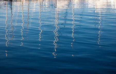 Reflection from masts on the water in the port. Water texture with reflections.の写真素材