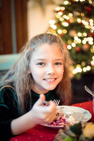 Little girl, teen daughter at a festive Christmas or New Year table close up.の写真素材