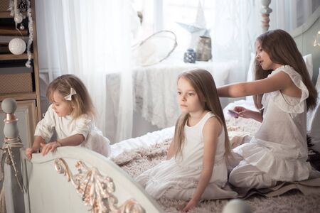 Girl combs her sisters hair in the bedroom.の写真素材