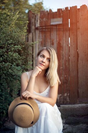 Woman in a hat and sundress for a walk in the country, summer sunny day.の写真素材