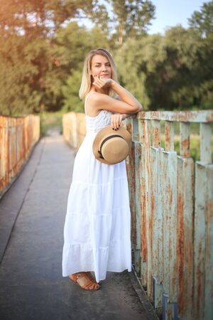 Woman in a hat and sundress for a walk in the country, summer sunny day.の写真素材
