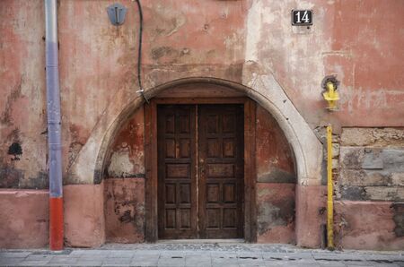 Old wooden door on the wall of a city house. An element of architecture. Europe.の写真素材