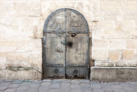 Old metal door on the wall of a city house. An element of architecture. Europe.の写真素材