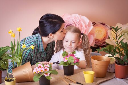 Cute child girl helps her mother to care for plants.の写真素材