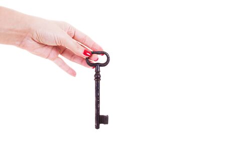 Female hand holds an old key. Isolated on white background.の写真素材