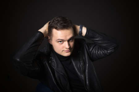 Portrait of an attractive man in the studio on a black background. Young serious guy.の写真素材