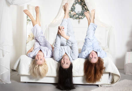 Young pretty women in the bedroom, pajama party or bachelorette party. Time for New Year's holidays and Christmas holidays. Christmas, new year, holiday.の写真素材