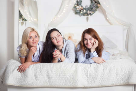 Young pretty women in the bedroom, pajama party or bachelorette party. Time for New Year's holidays and Christmas holidays. Christmas, new year, holiday.の写真素材
