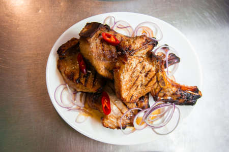 BBQ grill ribs served in portions in the restaurant kitchen. Plates with meat dish close-up.の写真素材