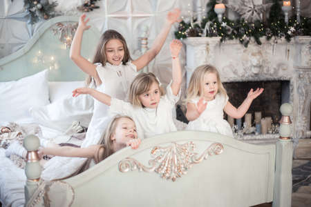 Little girls sisters in the morning in bed. Vintage style, Christmas holidays.の写真素材