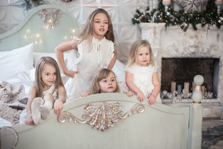 Little girls sisters in the morning in bed. Vintage style, Christmas holidays.の写真素材