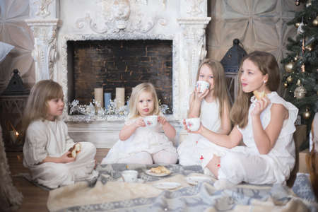 Girls sisters in winter morning drink tea winter christmas new year.の写真素材