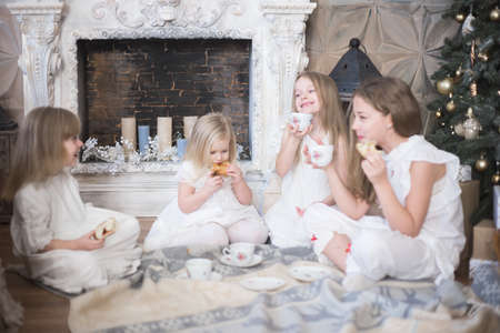 Girls sisters in winter morning drink tea winter christmas new year.の写真素材