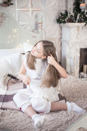 The girl is combing her hair in her bed in the morning. Retro style. High quality photoの写真素材