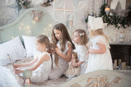 Little girls play in the bedroom in the morning before Christmas. The concept of family, sisterhood, friendship. Winter holidays, Christmas, New Year.の写真素材