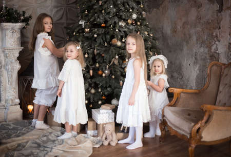Sister's children are decorating the Christmas tree. Family photo in retro style. Christmas and new year.の写真素材