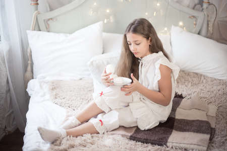 The girl is eating sweets in the morning in the bedroom. Winter holidays.の写真素材