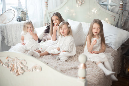 Girls sisters or friends eat sweets in the morning in the bedroom.の写真素材