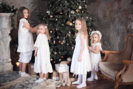 Sister's children are decorating the Christmas tree. Family photo in retro style. Christmas and new year.の写真素材