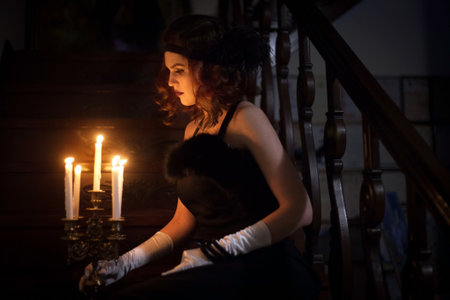 Woman in a vintage dress in the interior with candles.の写真素材