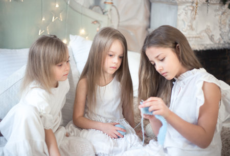 Little girls sisters or friends are doing needlework in the bedroom. Retro style.の写真素材